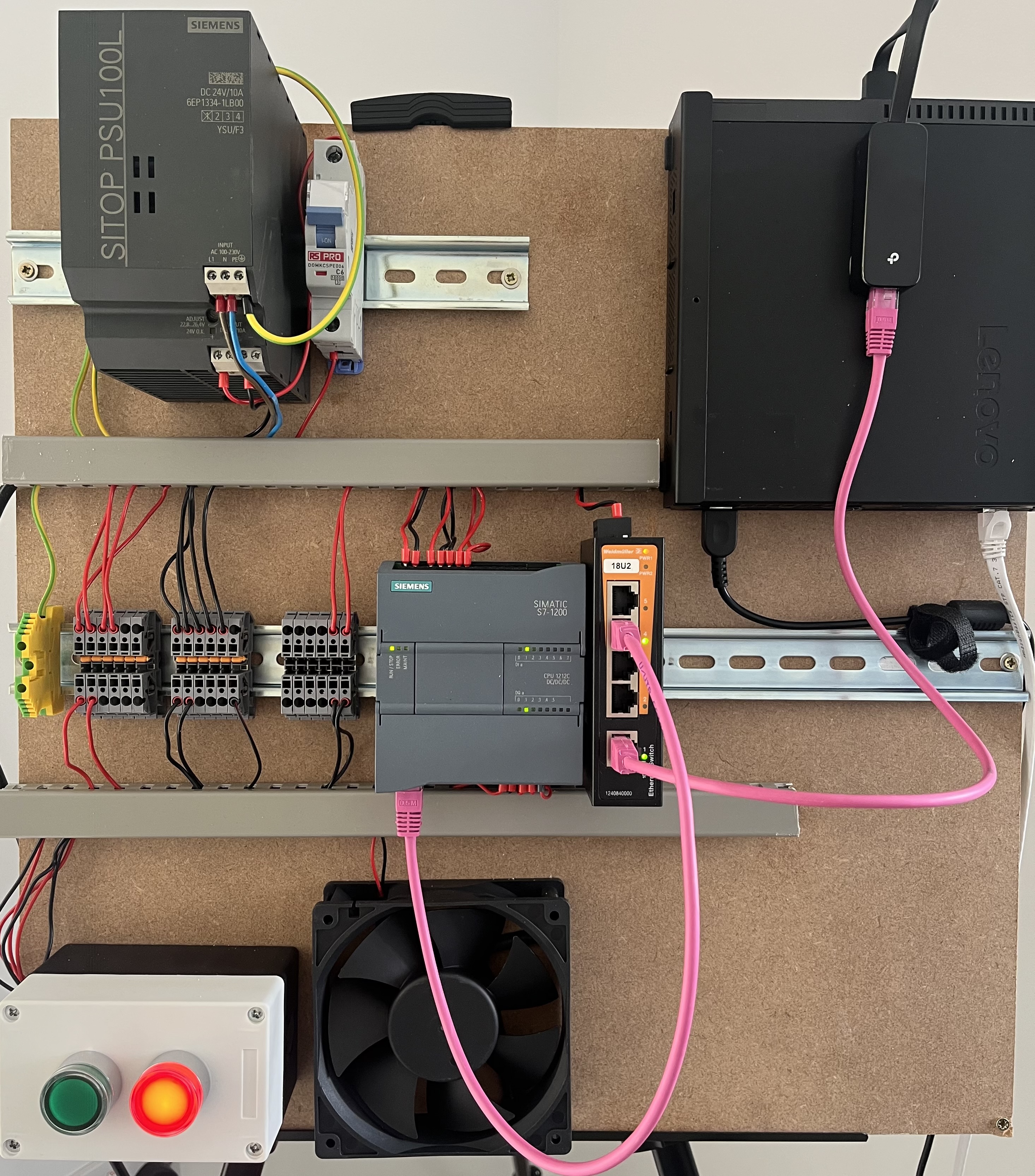 The completed OT lab on a plywood board, showing the Siemens S7-1200 PLC, power supply, ethernet switch, buttons and fan